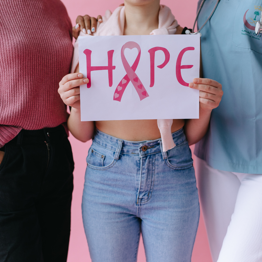 Women wearing pink holding poster and supporting breast cancer awareness