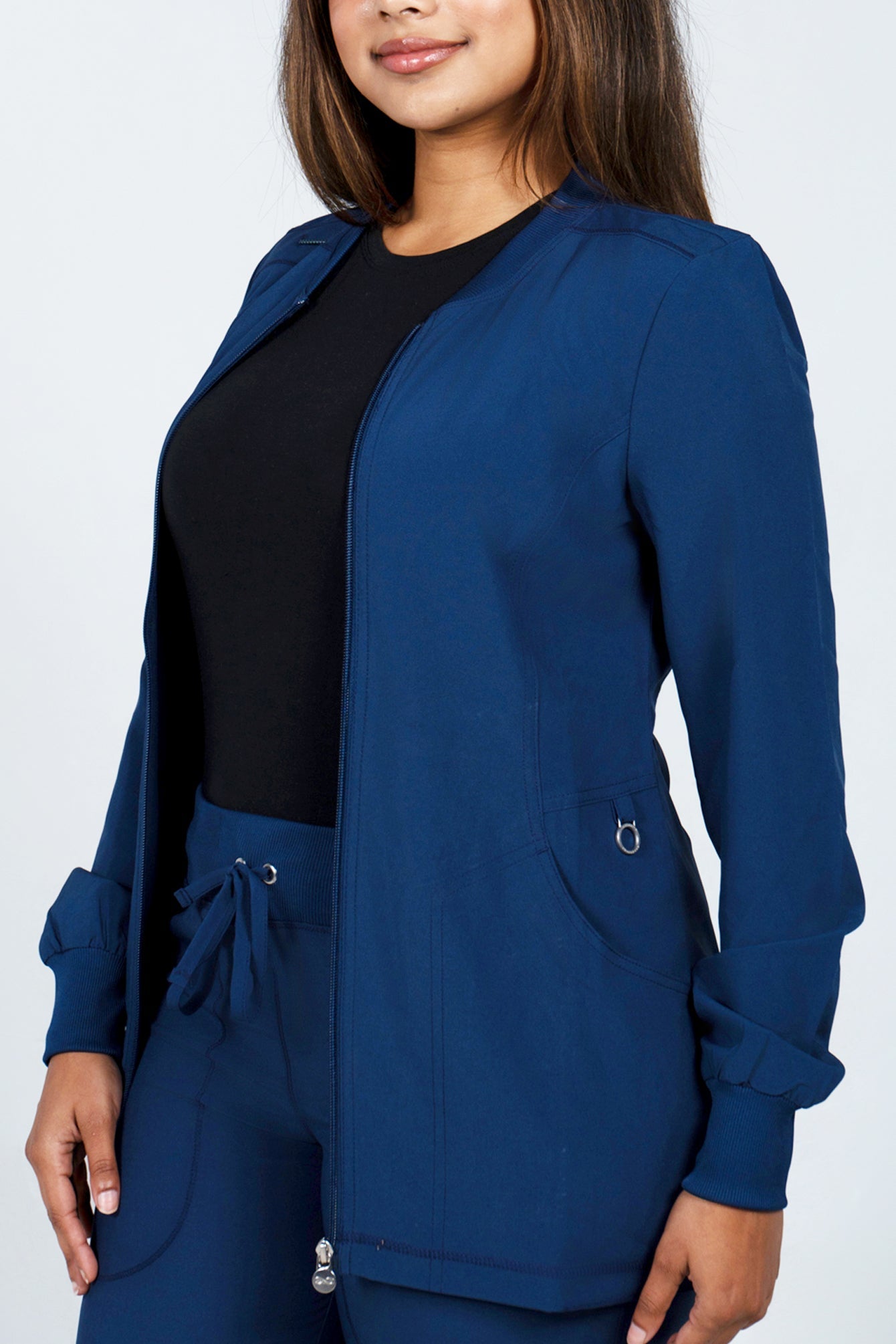 Healthcare worker wearing Rhino navy scrub jacket and pants with black underscrub top in plus size
