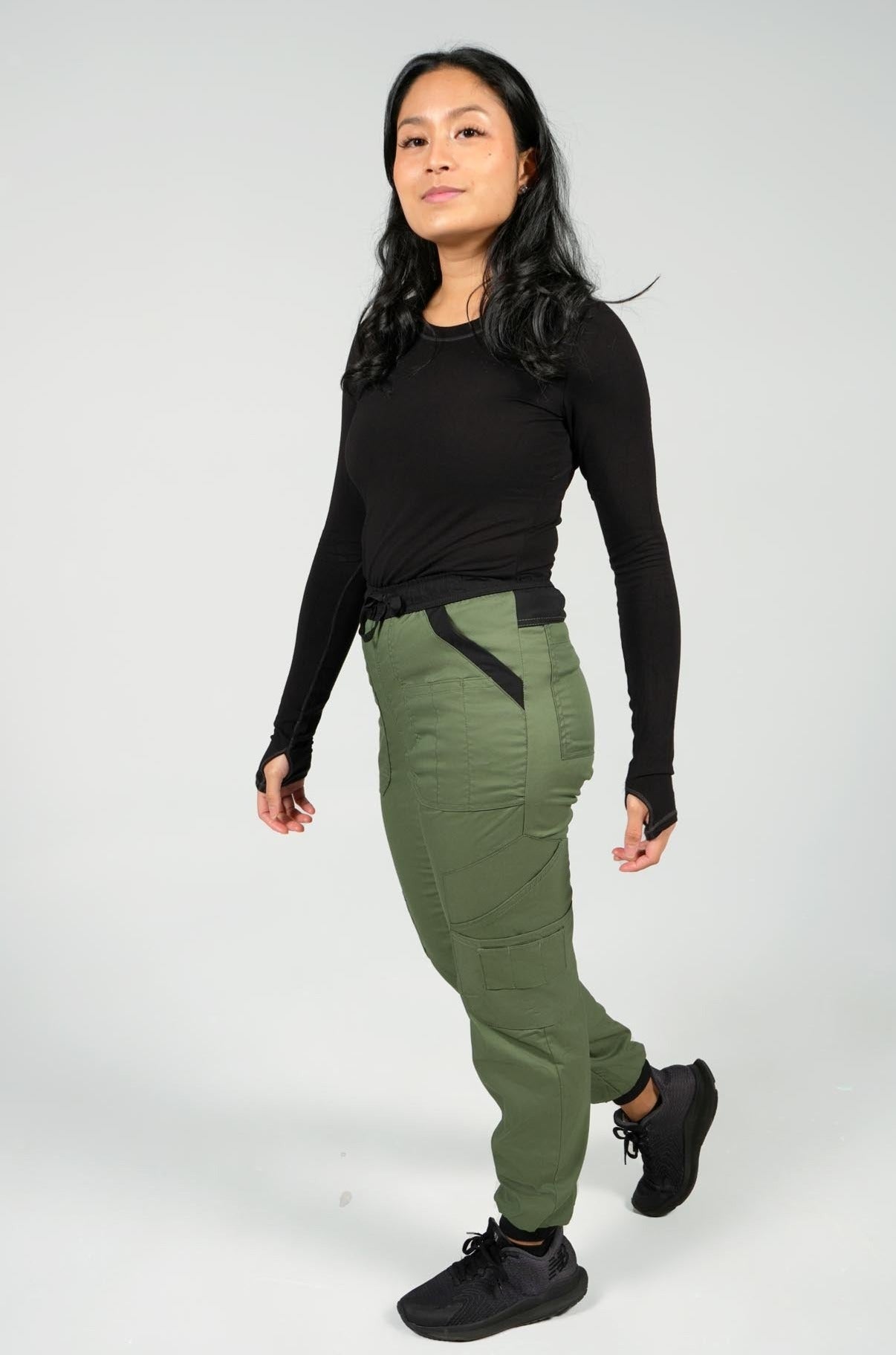 Nurse wearing women's black underscrub top and olive performance jogger scrubs