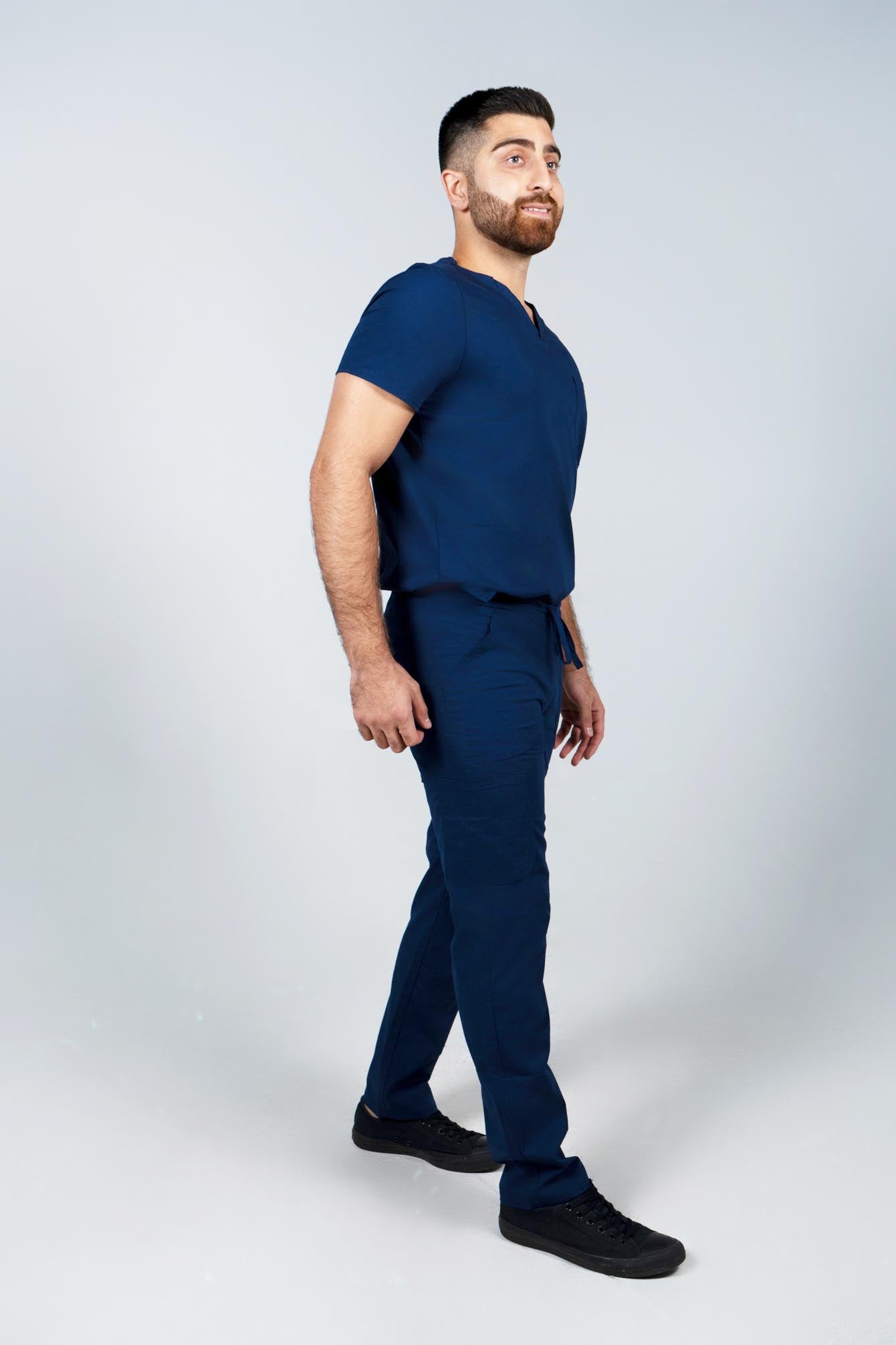 Male nurse wearing navy scrub top and bottom