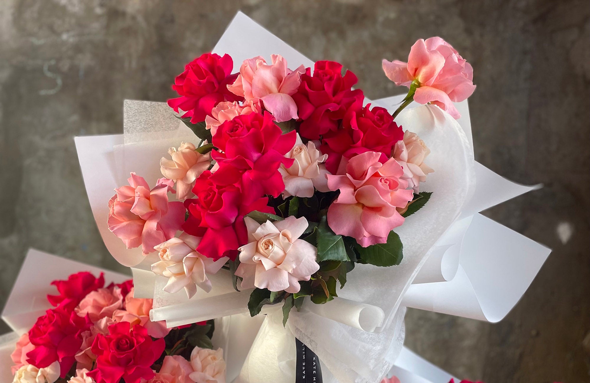 Mixed pink and red reflexed roses designed into a flower bouquet