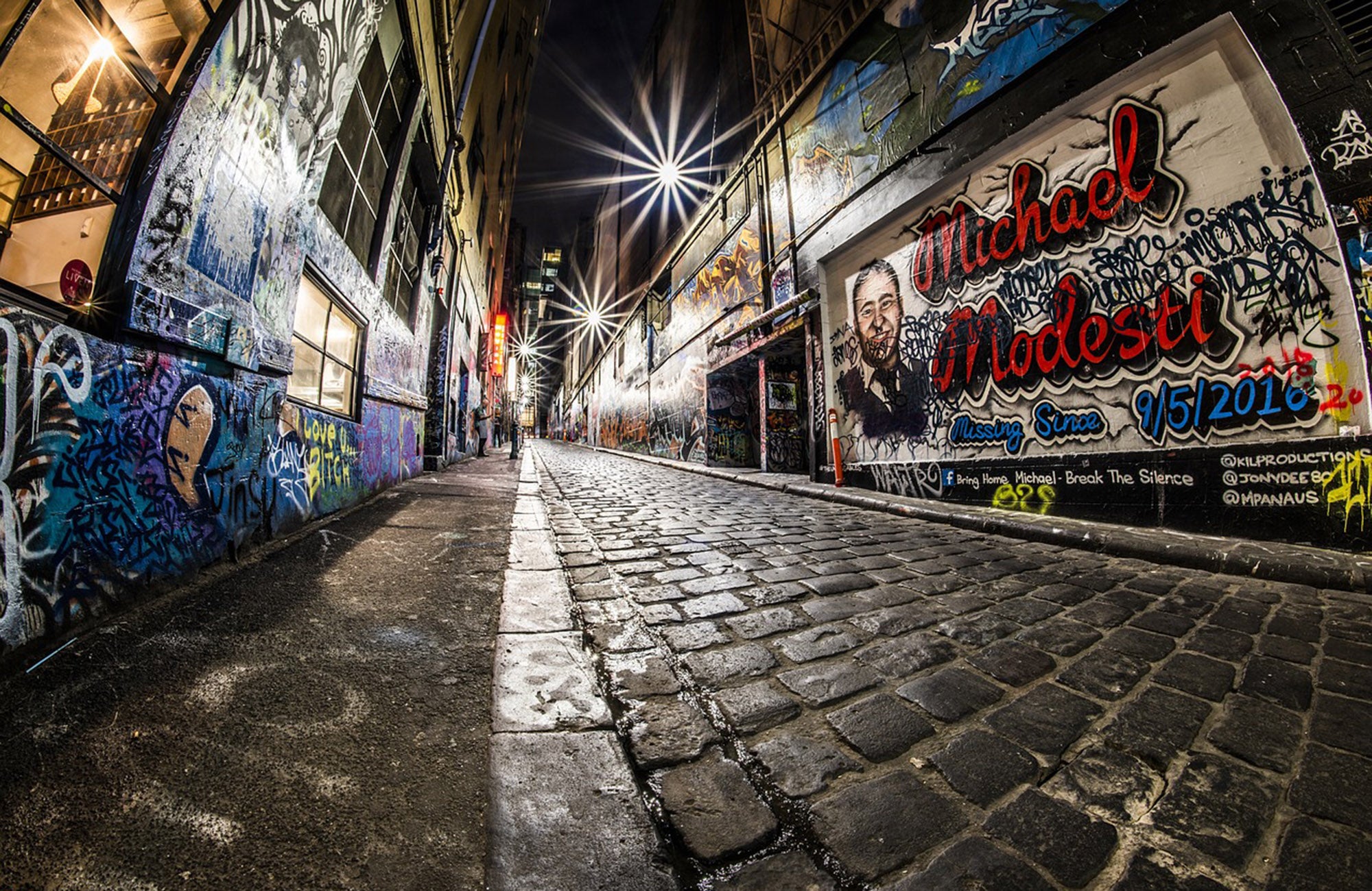 Wet laneway in Melbourne with graffiti on walls