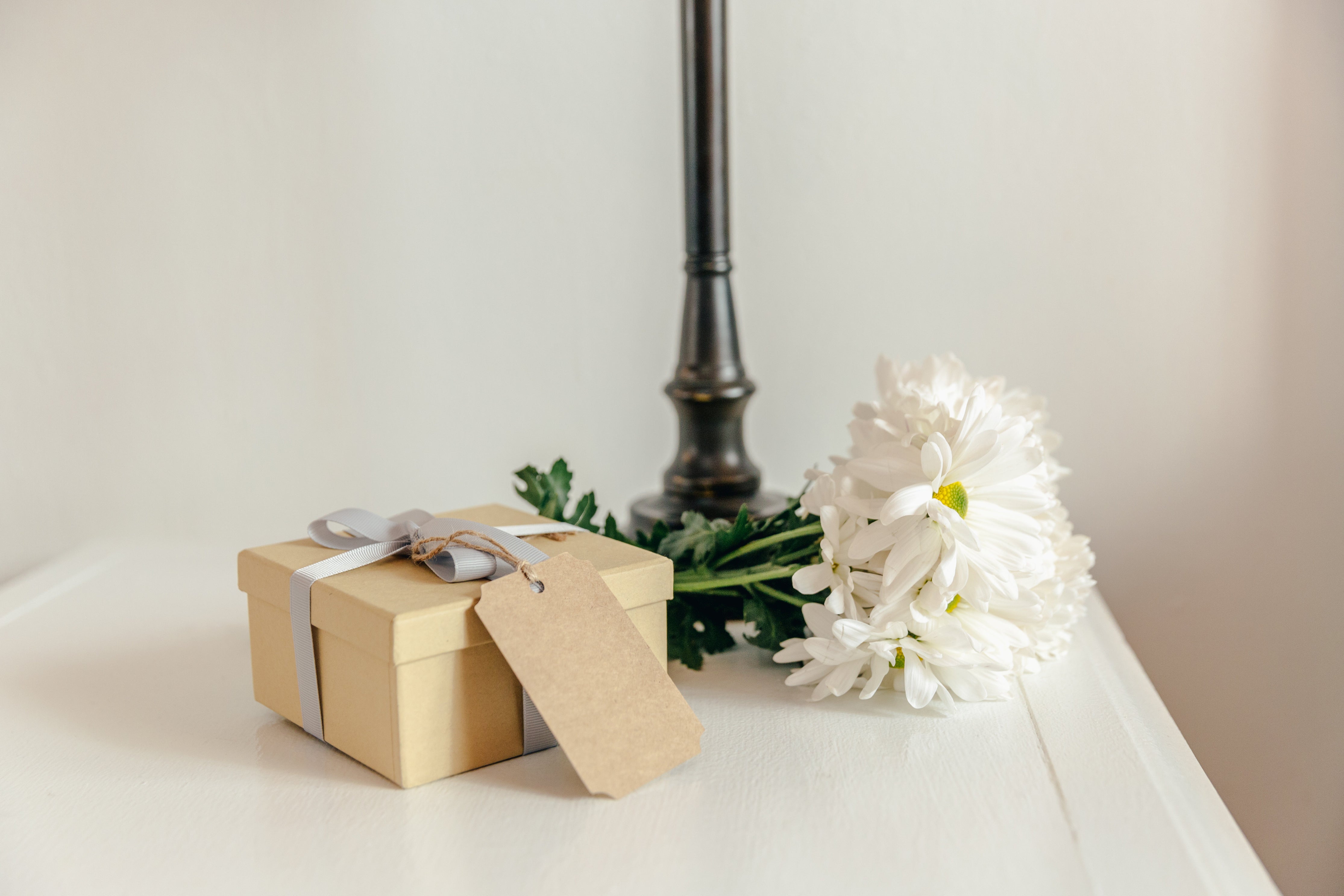 White flowers on bedside table with gift box