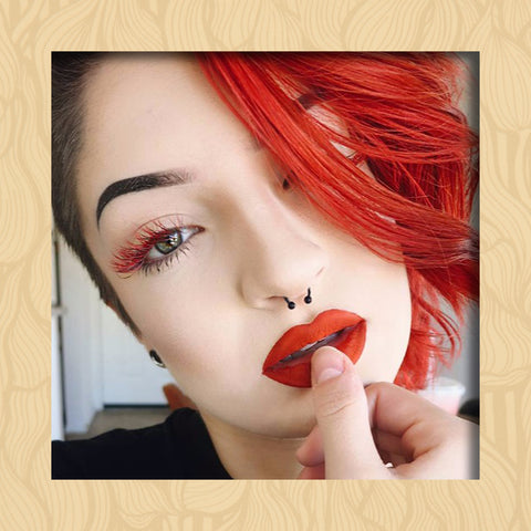 Image of a lash client matching her red lipstick, red hair and red colored eyelash extensions