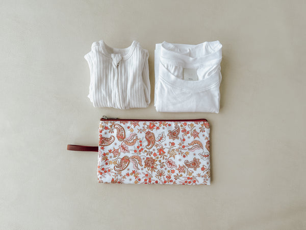 A wet bag filled with spare baby clothes, ready for any messes or spills while out and about with a little one.