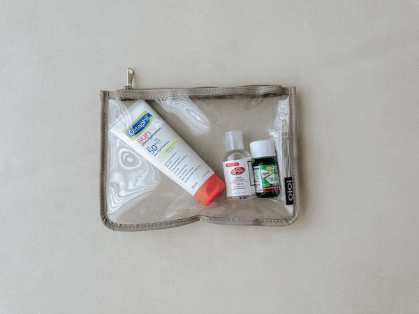 A clear medicine bag packed with sunscreen, ointment, and other essential items for a baby's outing. The bag is organized and ready to go, ensuring that everything is within easy reach when needed.
