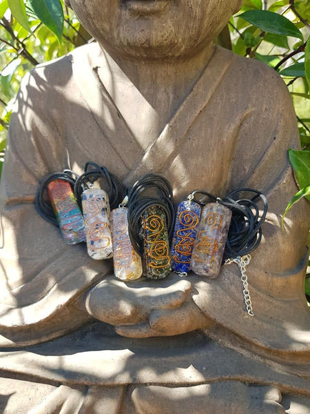 bouddha présentant 7 pendentifs orgonite générateurs d'ondes positives