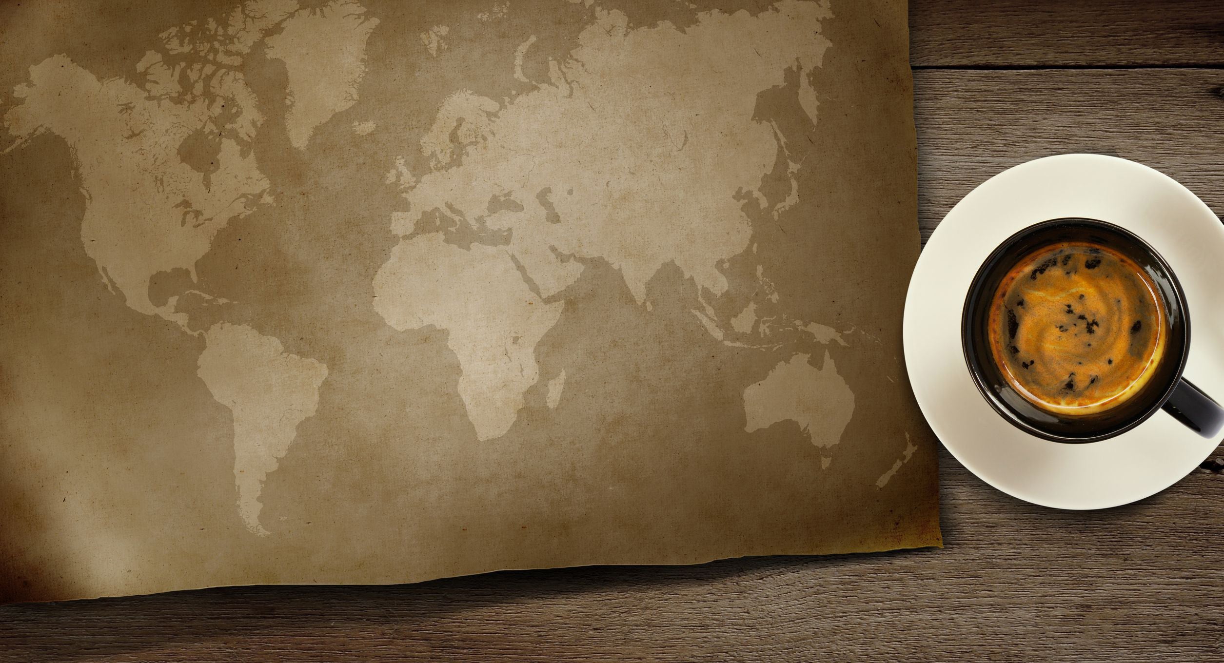 A coffee cup next to a world map