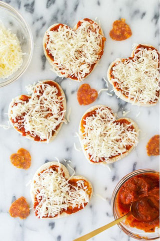 Pizzas hechas con pan pita, pasta de tomate, jamón y mucho queso.