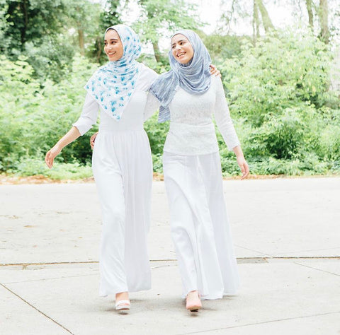 Sisters Hana and Ayah holding hands walking