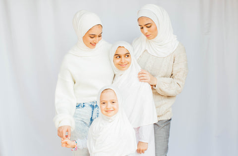 candid portrait with 4 sisters where everyone is wearing white