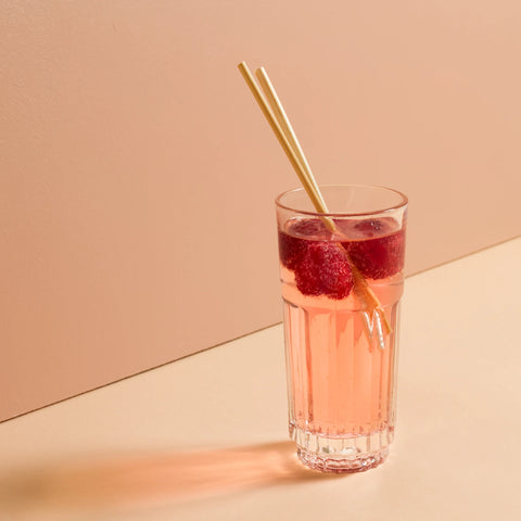 A chic cocktail in a longdrink glass with 2 pieces of wheat straws.