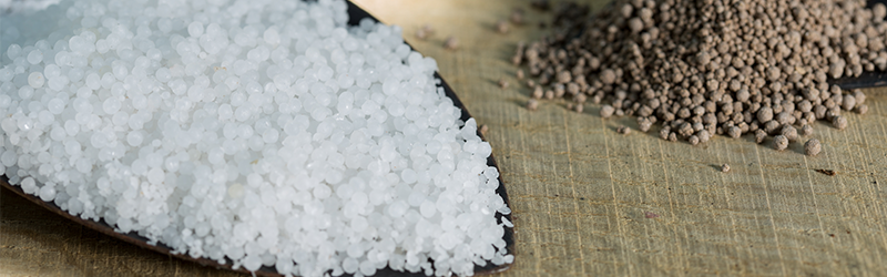 Close-up of some inorganic granular fertilizer on a table.