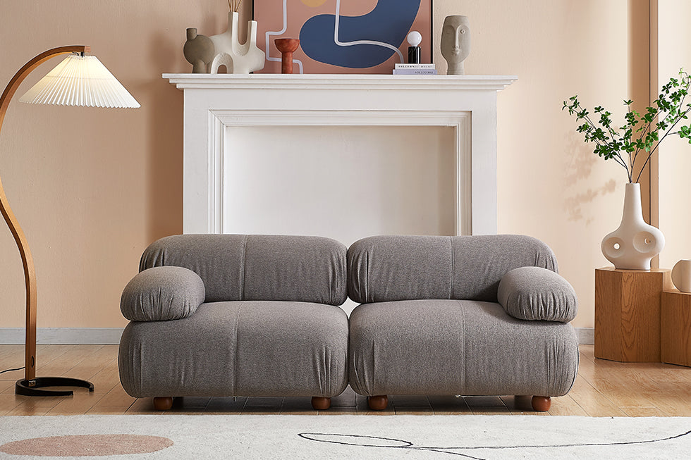 A modern sofa loveseat in grey linen.