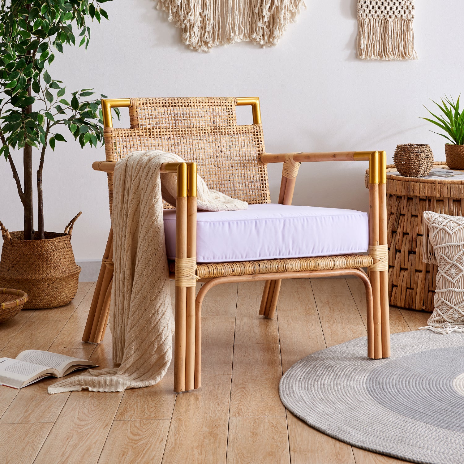 light and airy wicker chair with white cushion and beige throw. Set in a coastal themed room with macrame and potted plant decor.