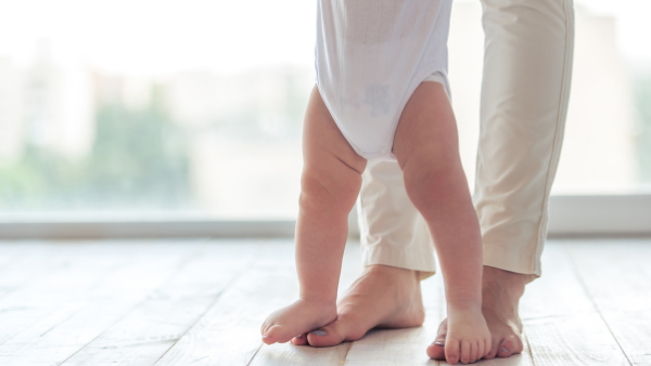  Baby standing on adults feet trying to walk