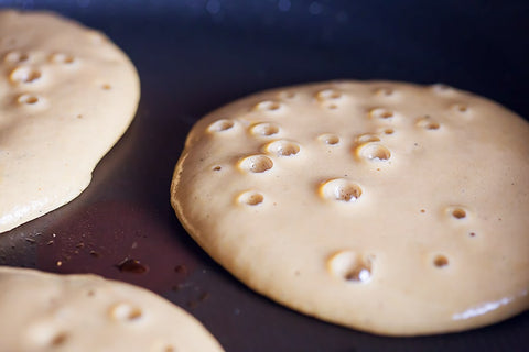 fluffy pancakes in frying pan