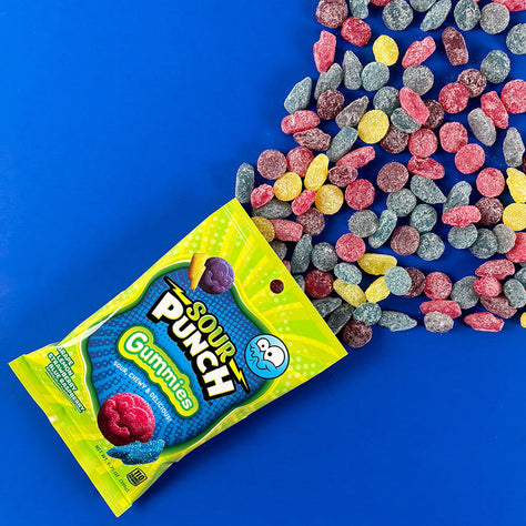 Sour Punch Gummies candy bag on a blue background with candy falling out of bag