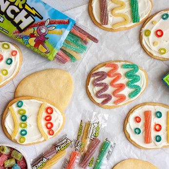 Egg shaped cookies with white frosting and Sour Punch candy decorations