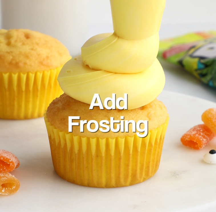 Frosting being piped onto a cupcake in a swirl motion