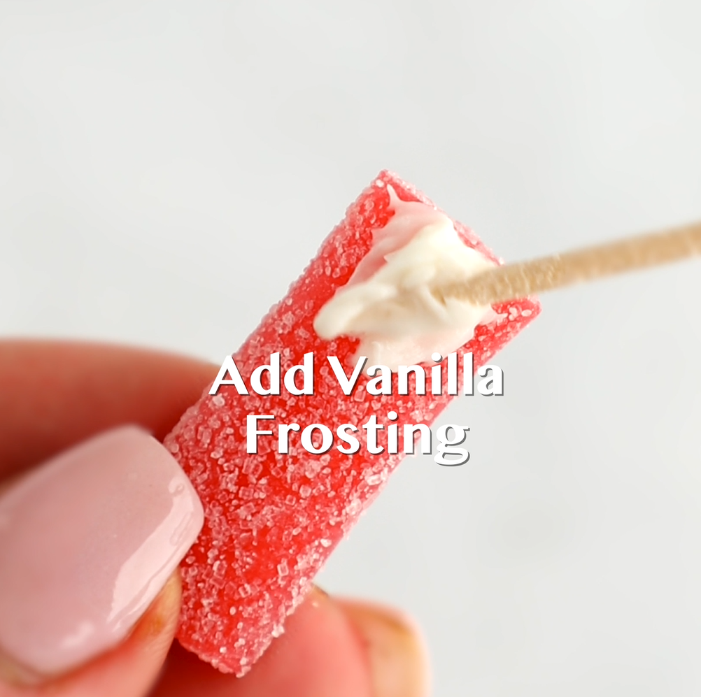 Vanilla frosting being added to the tip of the Sour Punch candy bite