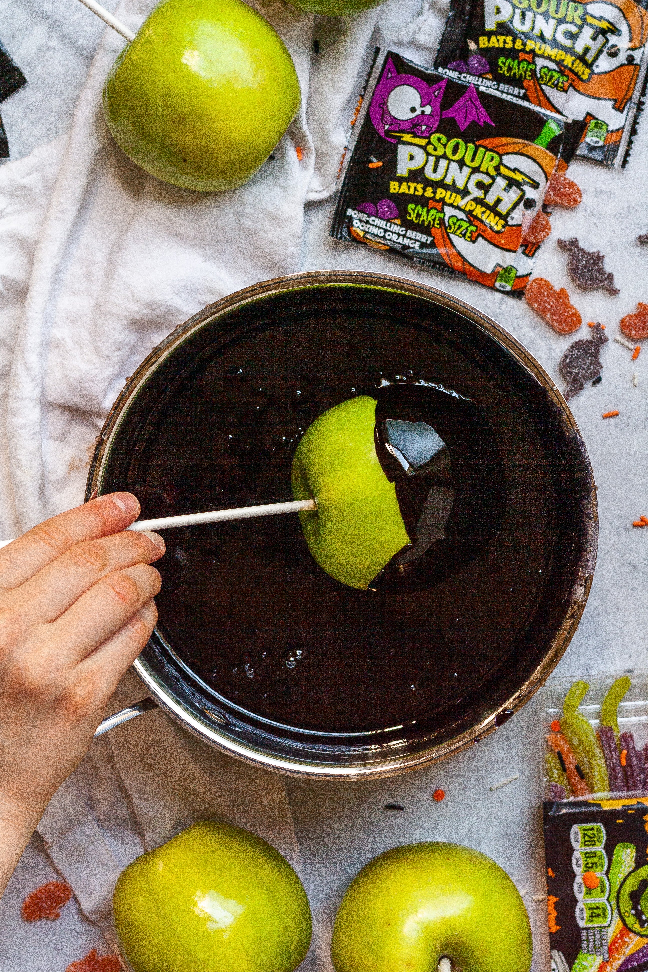 Dipping a green apple into the coating mixture