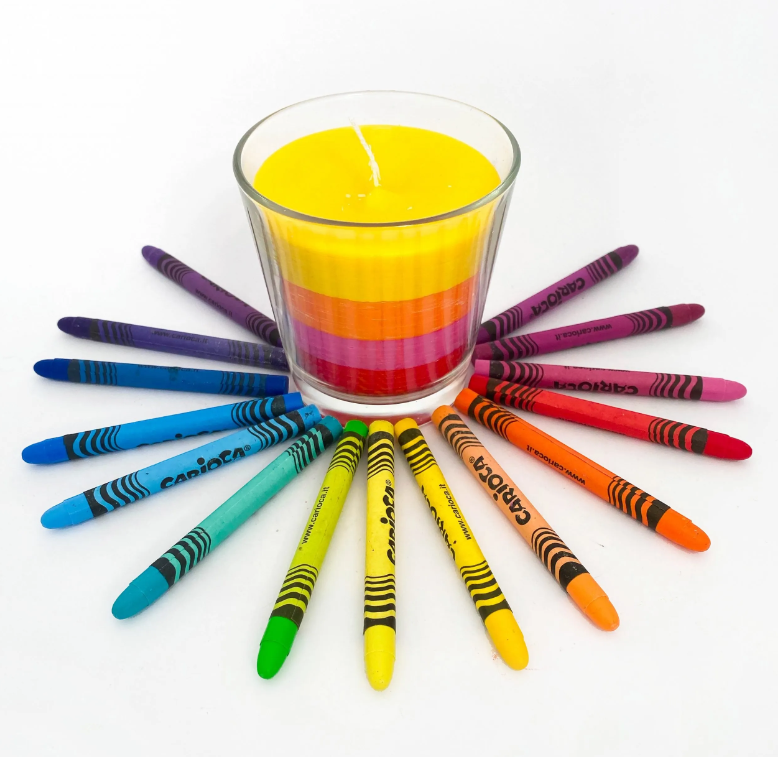 Crayons and crayon candle on white background