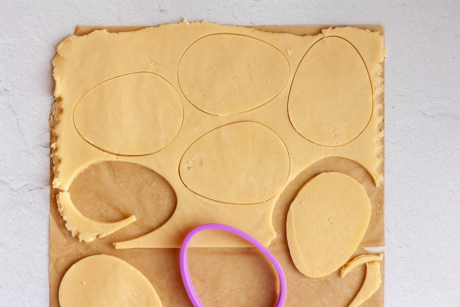 Cutting egg shapes out of cookie dough