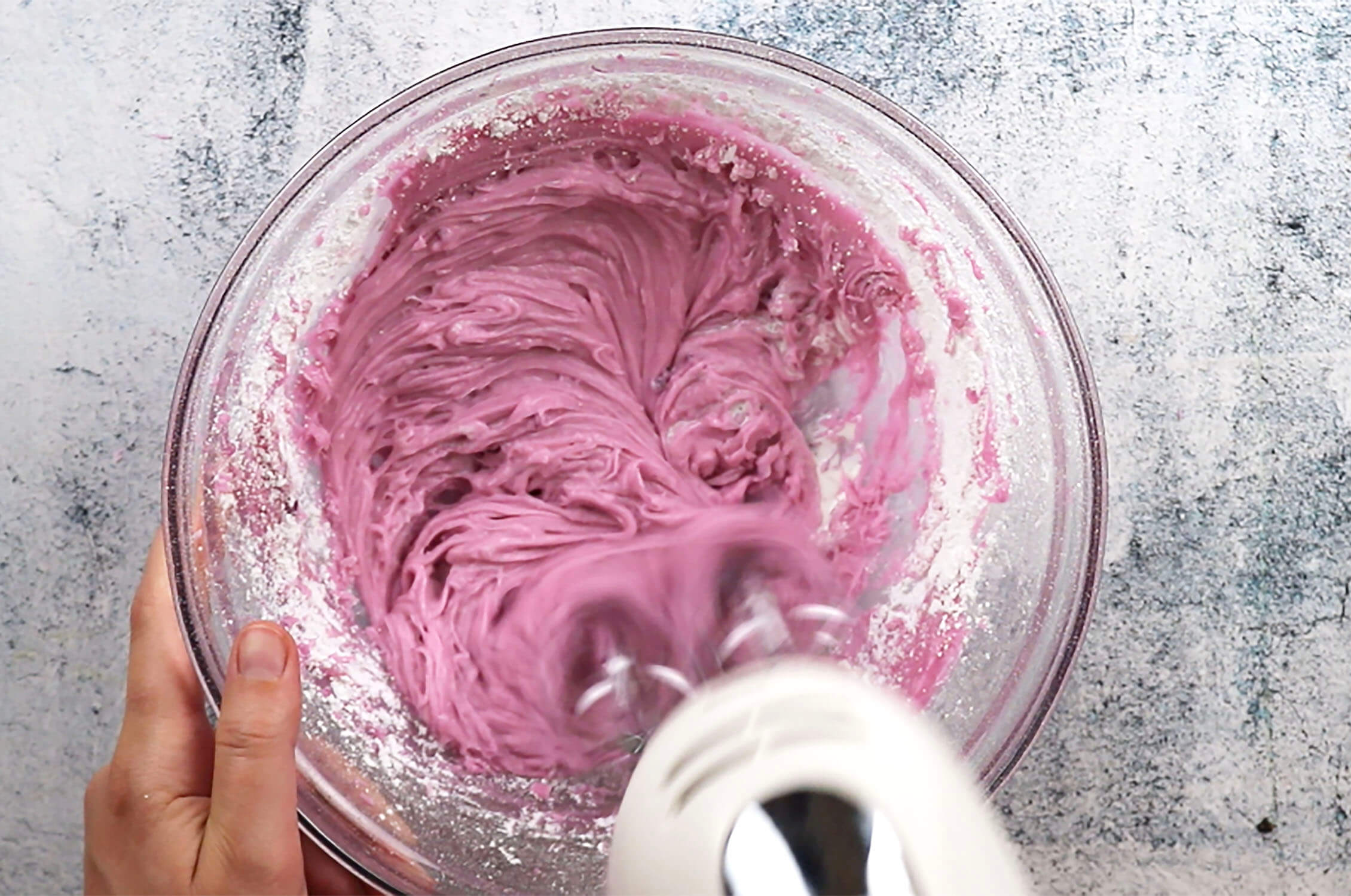 Beating Grape flavored frosting in a bowl