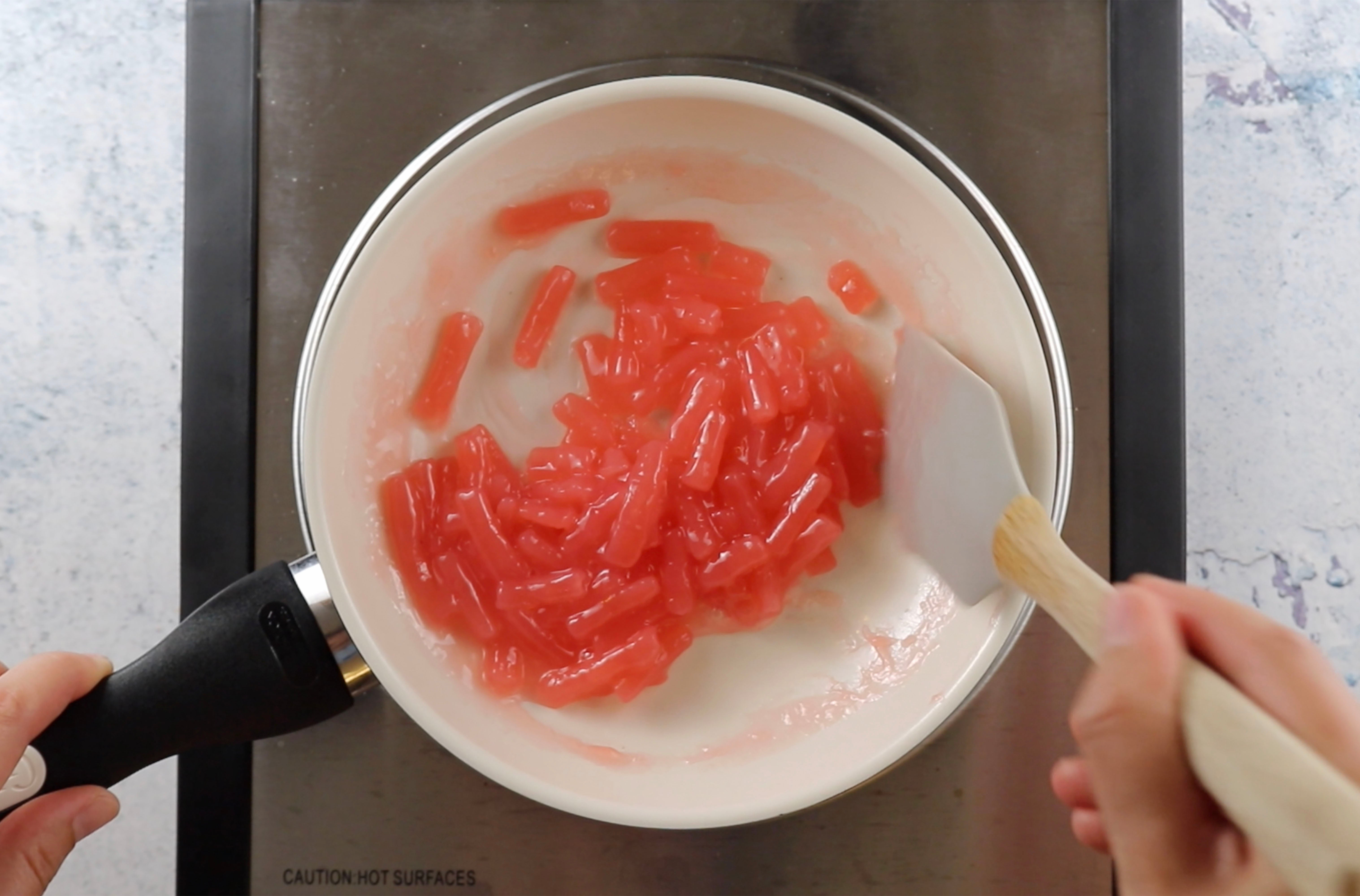 Pieces of Sour Punch Strawberry Straws simmering in a saucepan