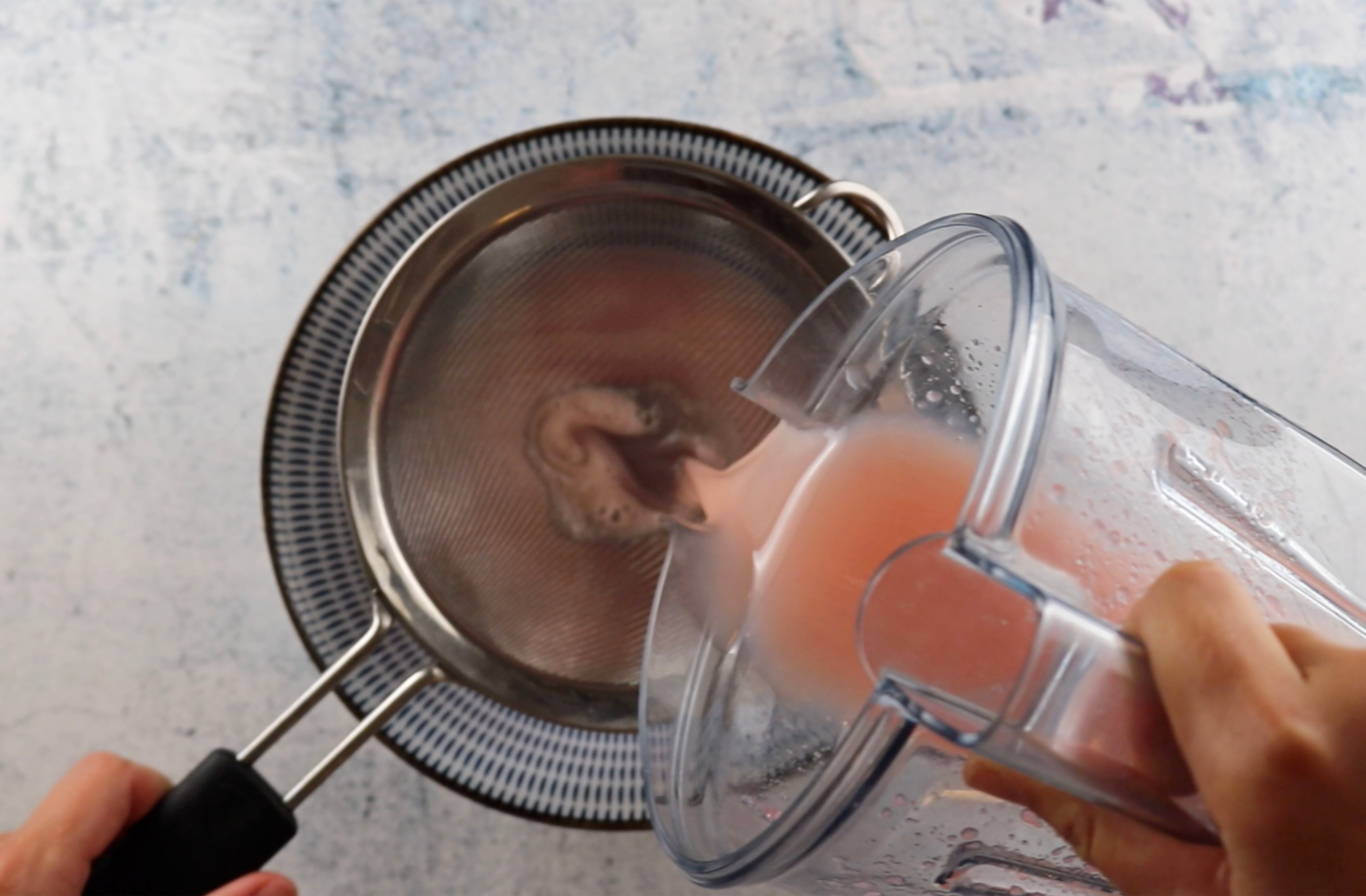 Sour Punch Strawberry Straws blended mixture being strained into a bowl