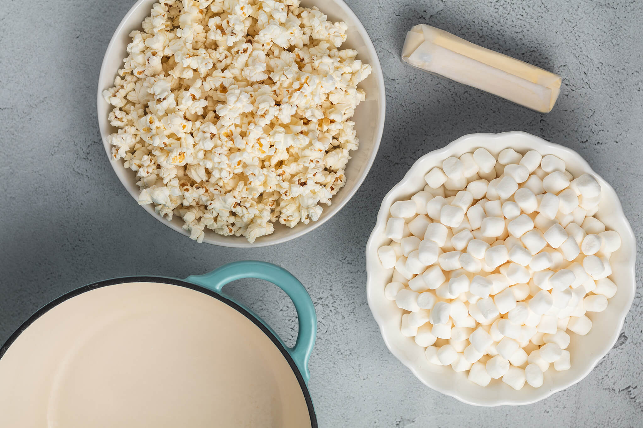 Cooked popcorn, mini marshmallows, butter, and a cooking pot