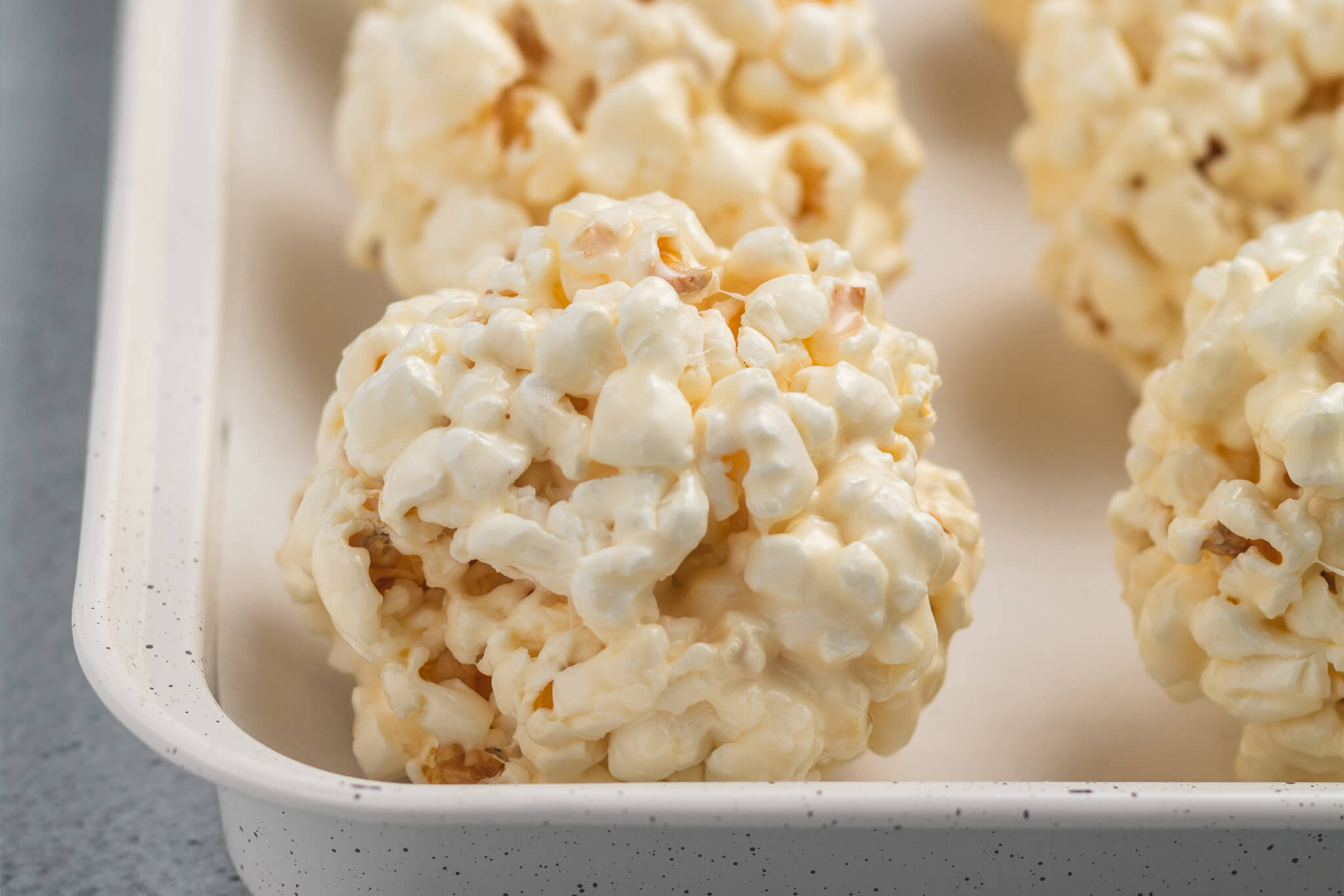 Marshmallow popcorn formed into balls on a lined cookie sheet