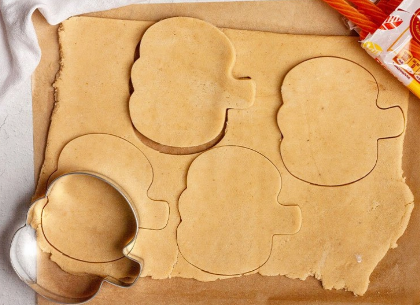 Cookie dough cut into pumpkin shapes