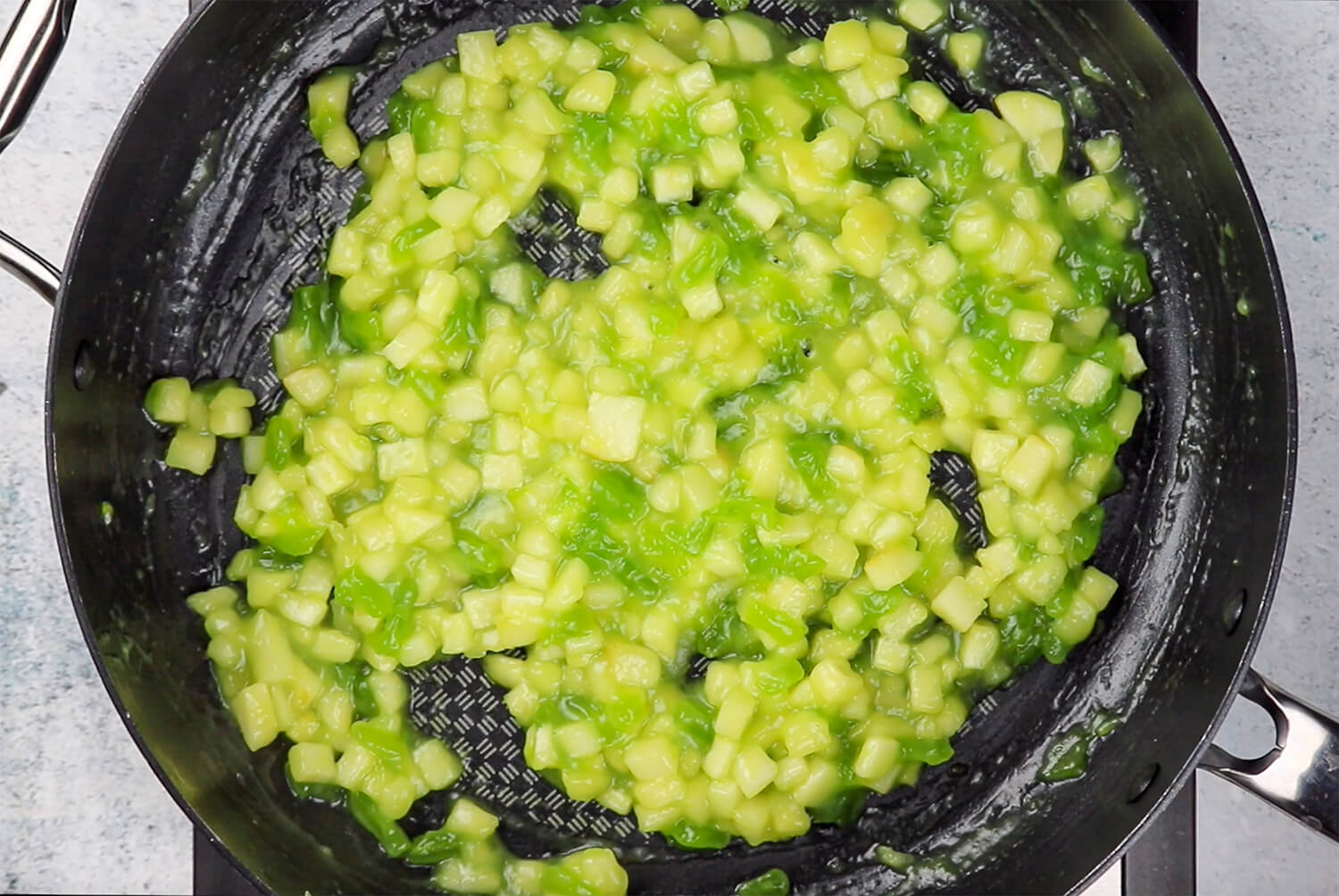 Green apples and Sour Punch Straws cooking in a pan