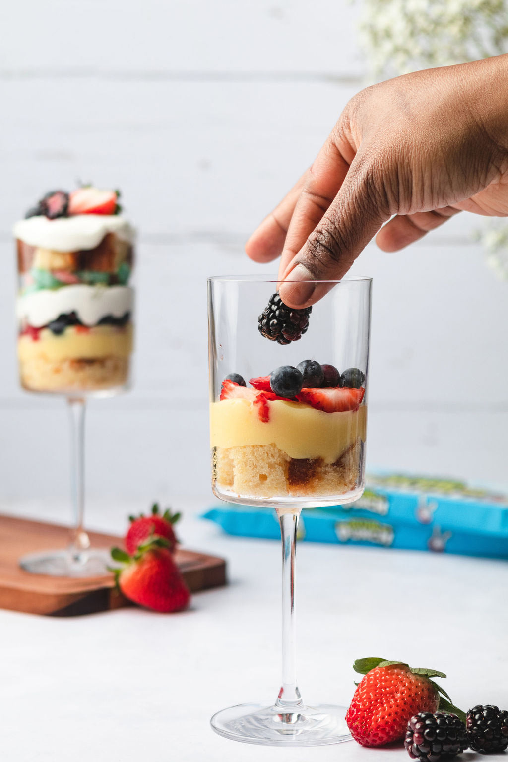 Layering mixed berries on top of the pudding and cake