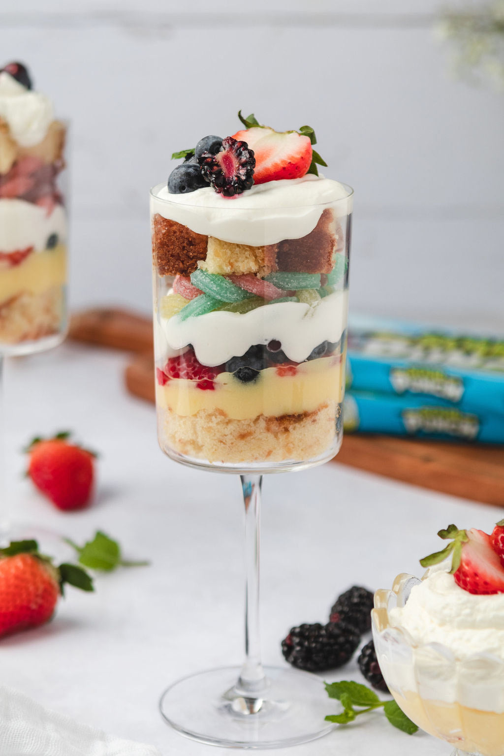 Repeated layers of whipped cream, Easter candy Straws, mixed berries, pudding, and cake to make a trifle
