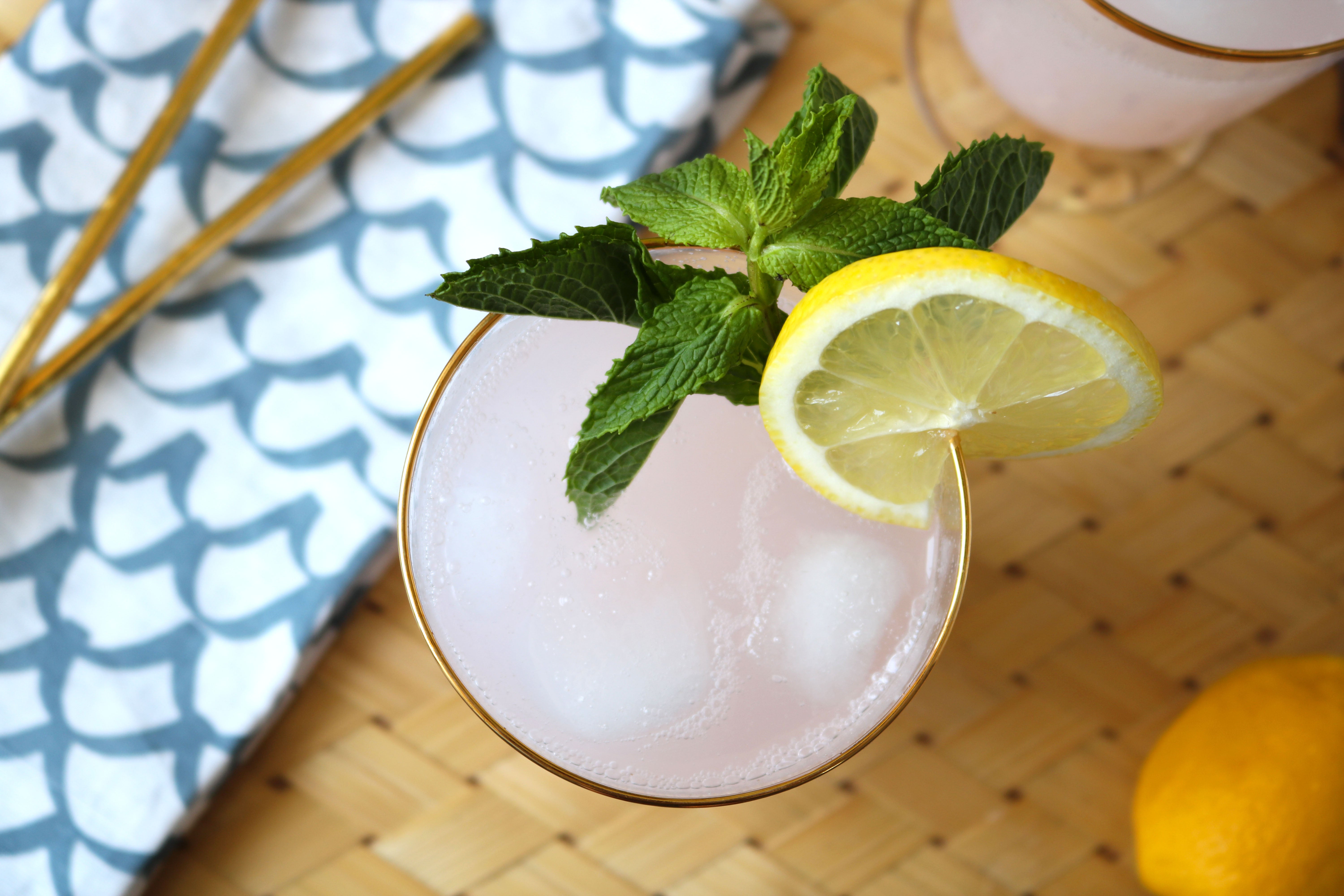 Sour Punch Sparkling Strawberry Mint Lemonade in a glass on a wicker serving tray