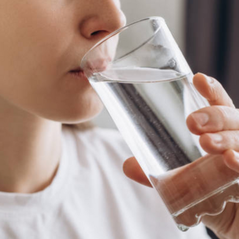 persona tomando un vaso con agua