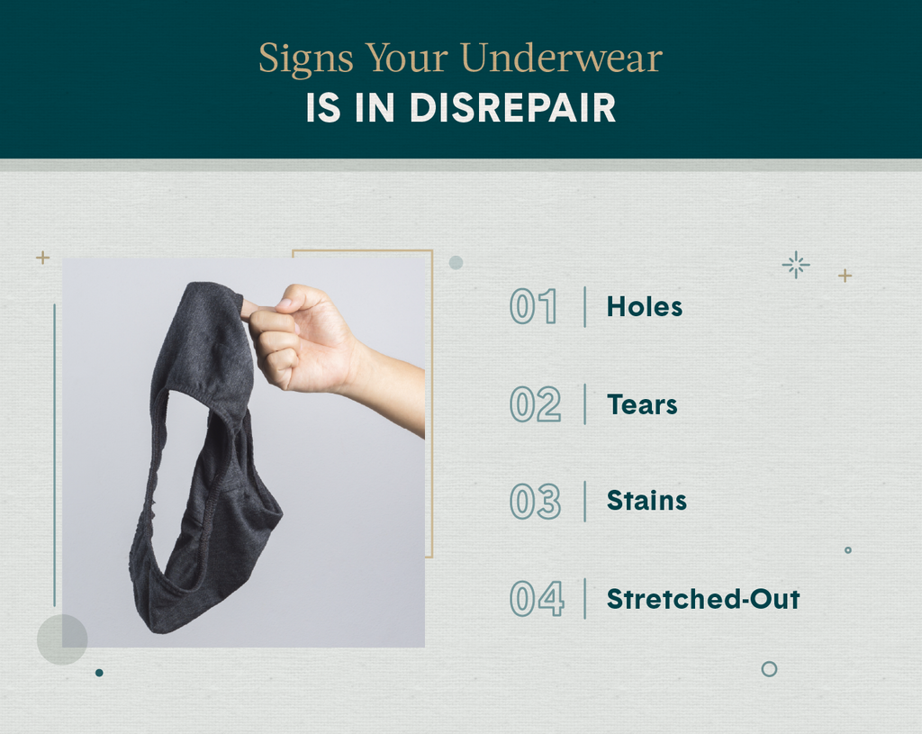 A hand holding up an old pair of underwear representing the signs you should look for when deciding how often you should buy new underwear