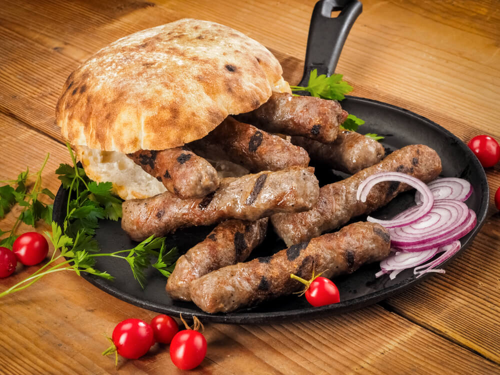 Grilled Cevapi With Roasted Bread Bun in a Pan on Wood