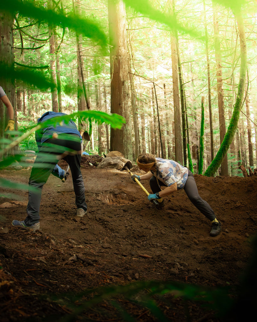 Digging up and reshaping a berm at a Steed Cycles trail day