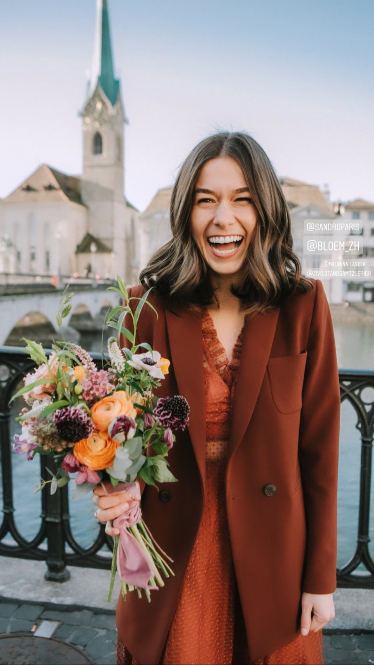 Die Braut hält einen Blumenstrauss und lächelt