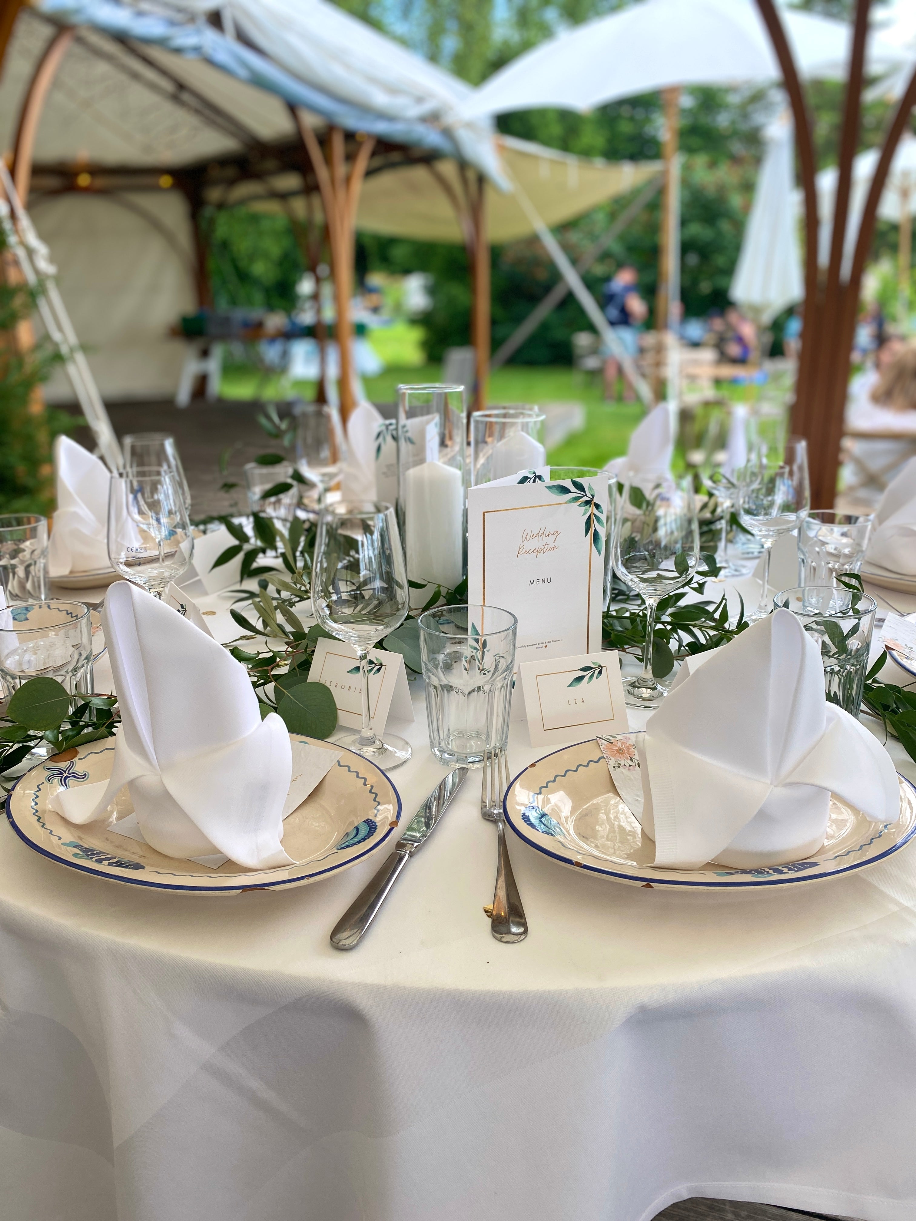 Tischdekoration für eine Hochzeit mit verschiedenen Arten von Blättern