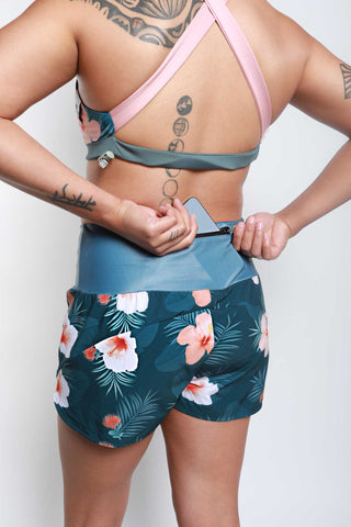 Woman wearing Hakuna Wear Endless Athletic Shorts - 'Ohi'a Hibiscus showing pocket feature