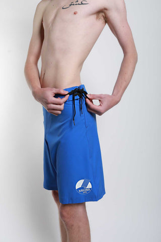 male wearing blue Hakuna recycle material surf board shorts with tie on the side