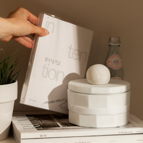 An image of a person taking the Intention Notebook from a shelf.