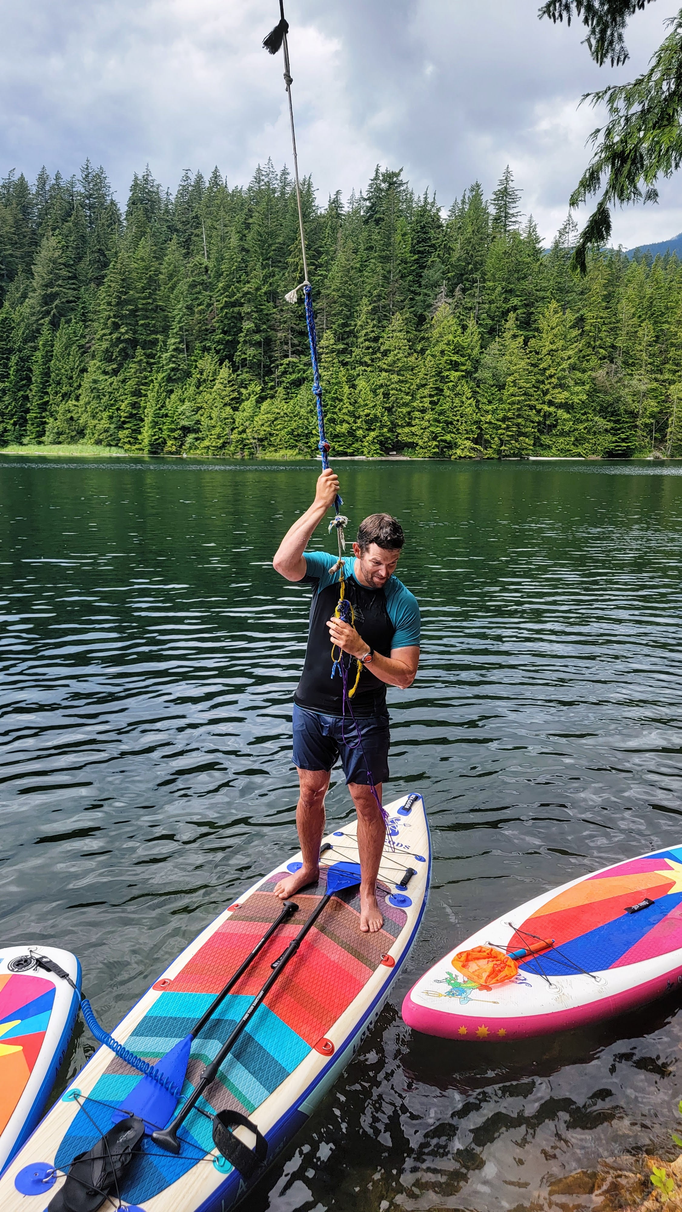 Man having an adventure at a lake with a family of Sea Gods Stand Up Paddle boards