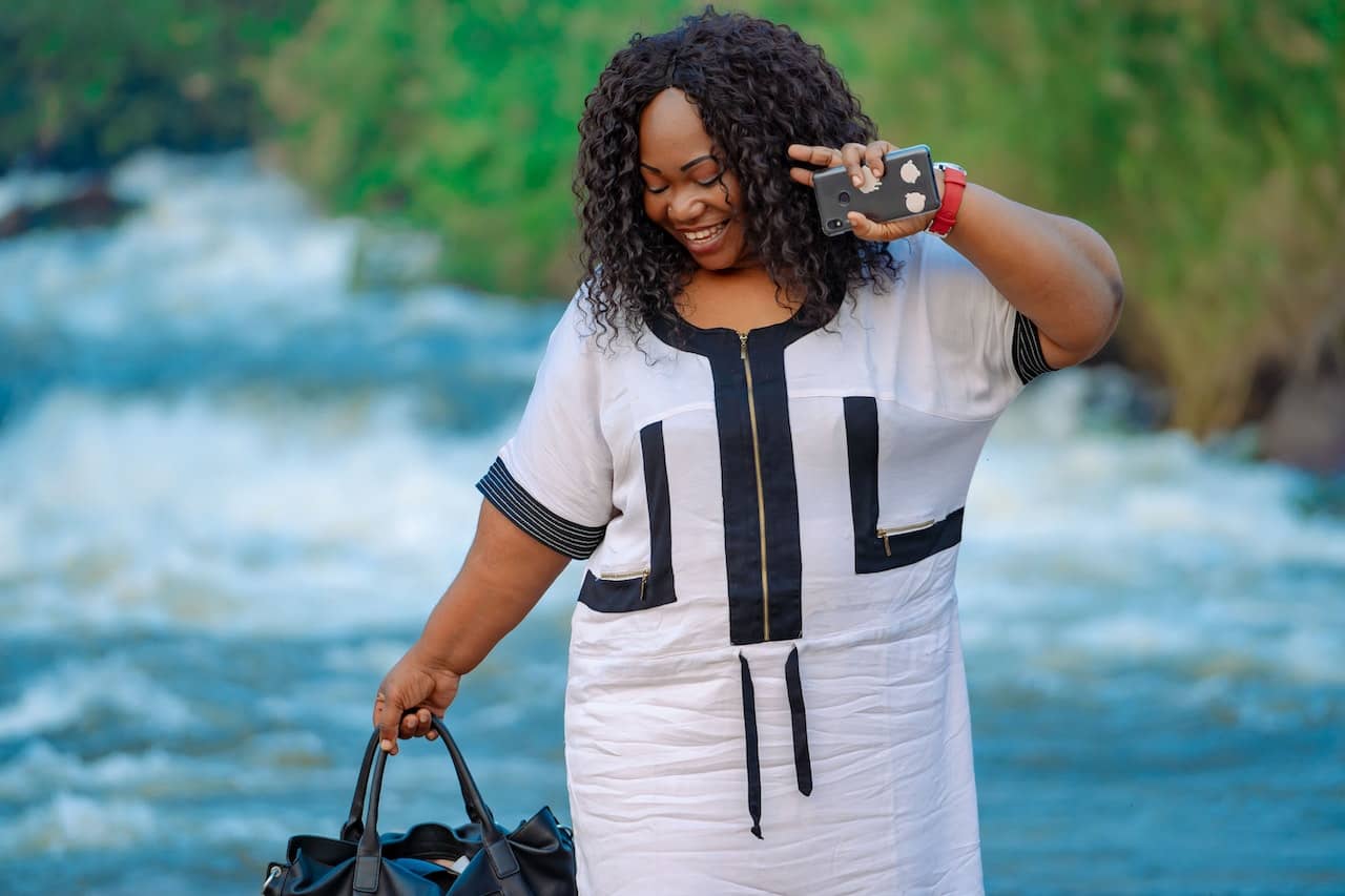 A plus-size woman smiling and holding a bag 