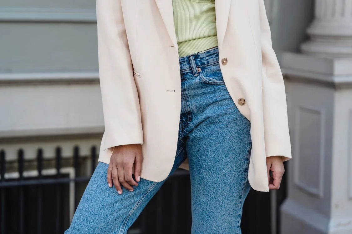 A woman wearing a beige jacket and jeans